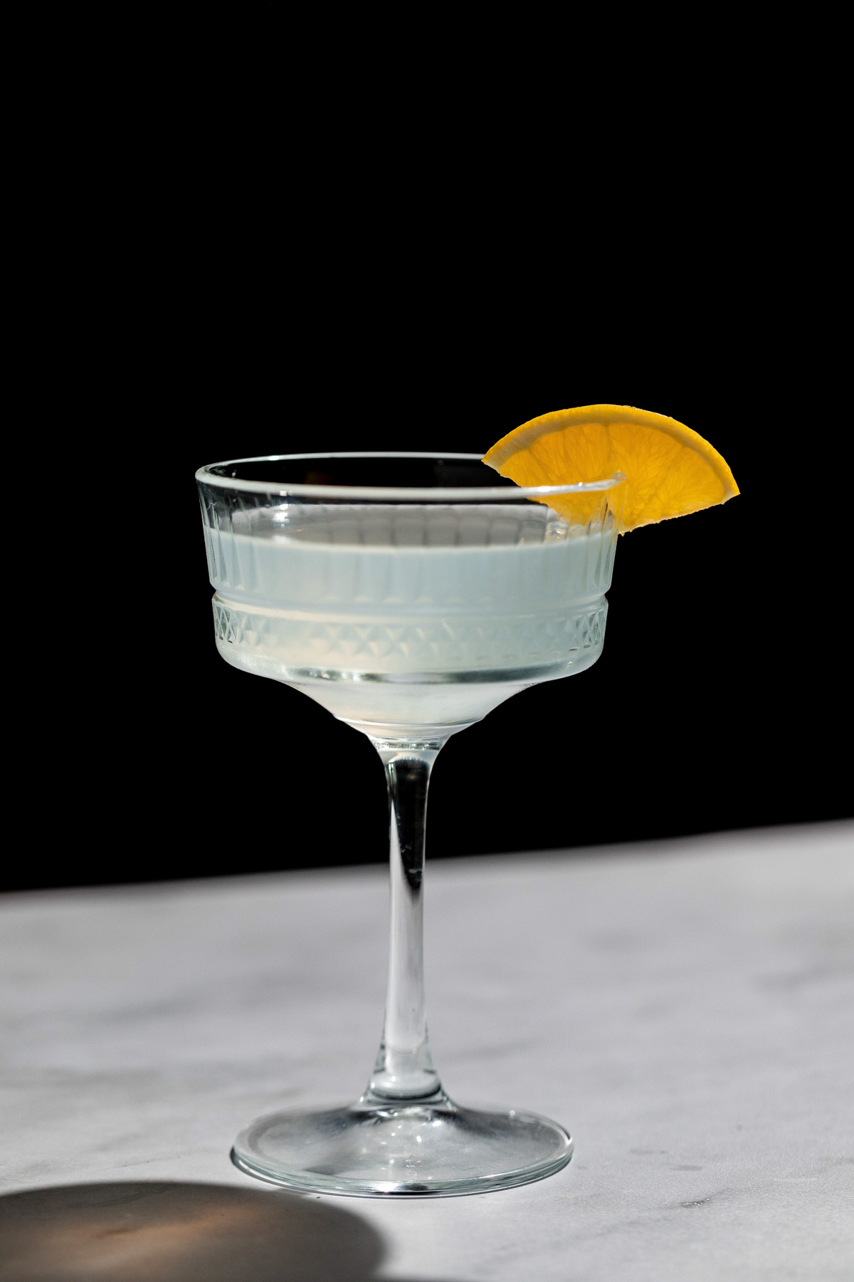 Corpse Reviver cocktail with an orange wedge in a cocktail glass.