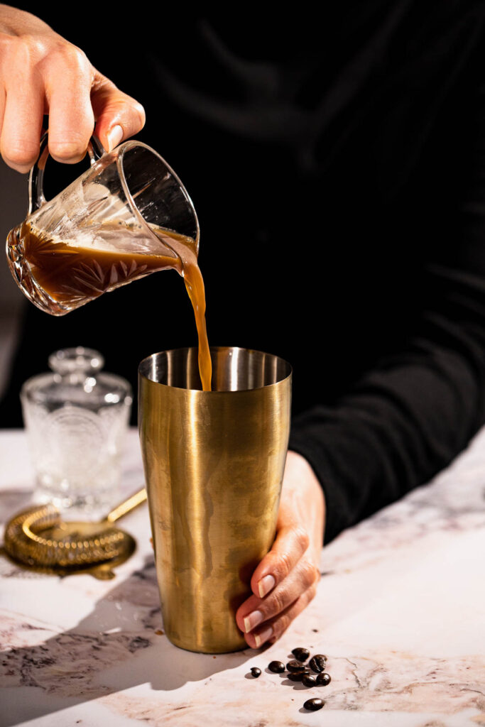 Pouring espresso into cocktail shaker.