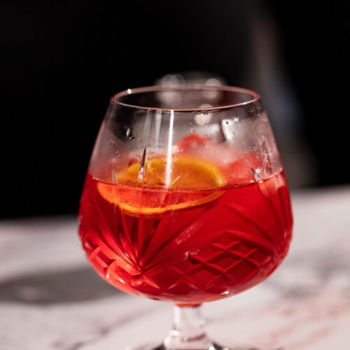 Mezcal negroni in a snifter glass.