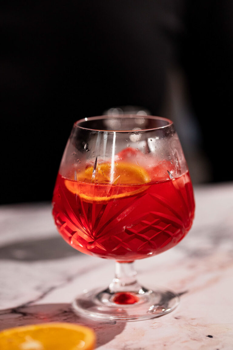 Mezcal negroni in a snifter glass.