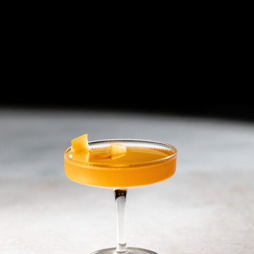 Sidecar cocktail with an orange twist for garnish in a cocktail glass.