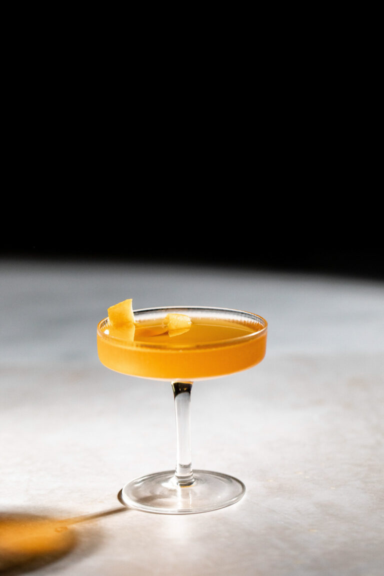 Sidecar cocktail with an orange twist for garnish in a cocktail glass.