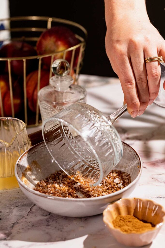 Cocktail glass being dipped in sugar spice to rim the edge.