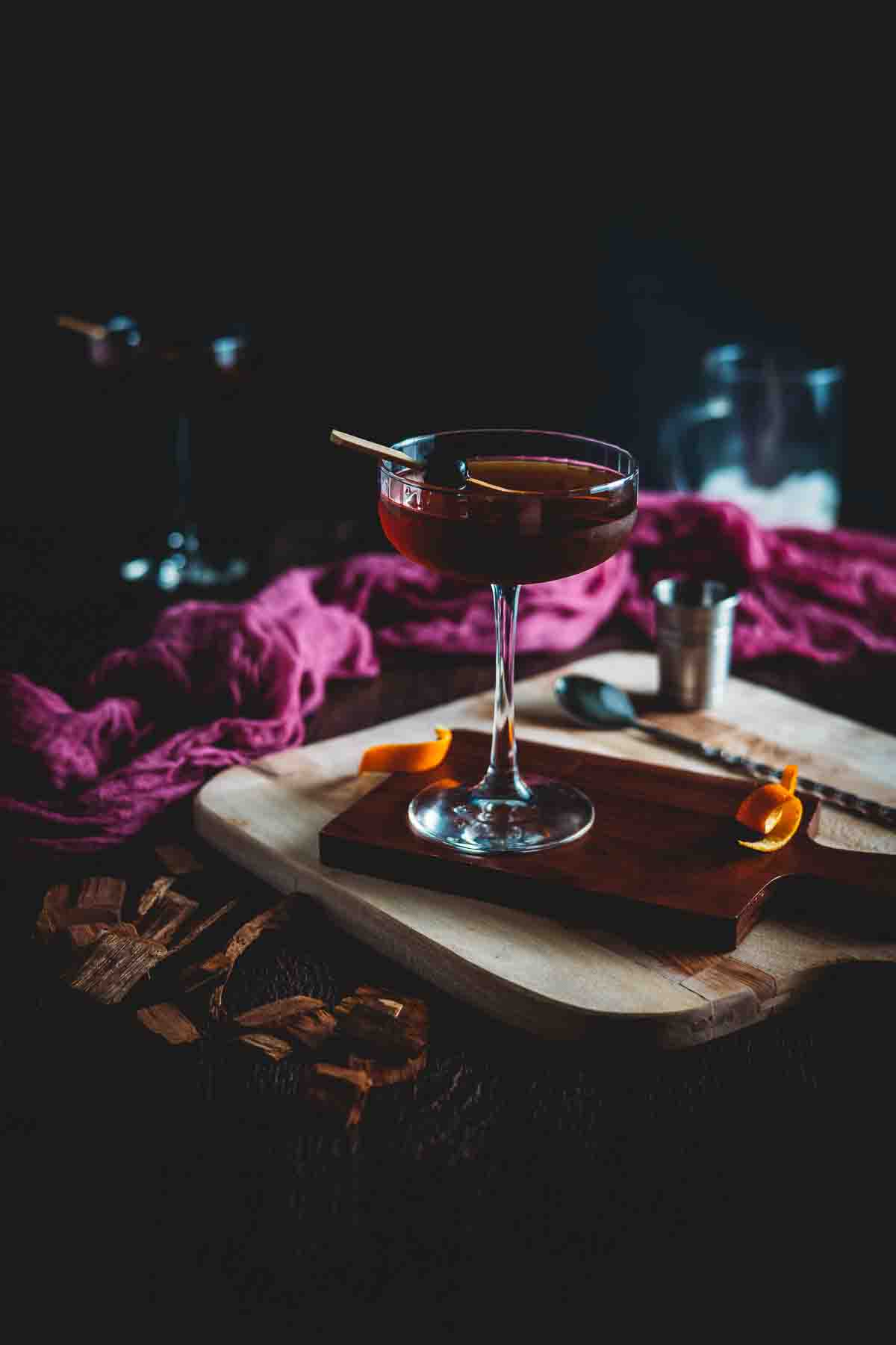 Dark photo of a smoked manhattan cocktail.