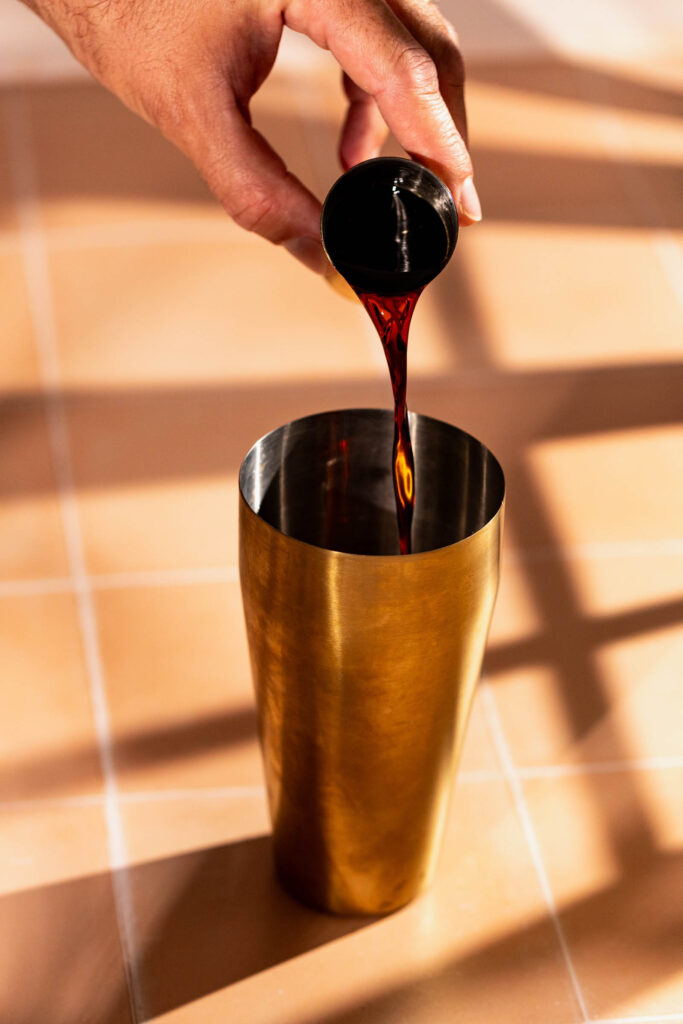 Kahlúa being poured into a cocktail shaker.