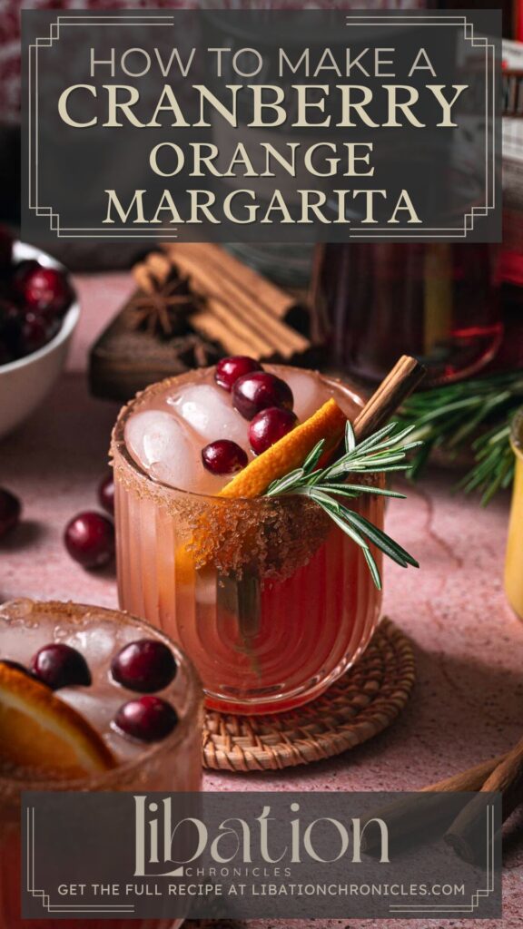 Cranberry orange margarita in a glass with festive garnishes on a woven coaster, cocktail ingredients in the background.